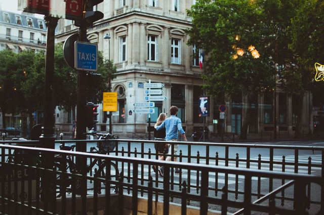Rue animée d'un quartier parisien à la tombée de la nuit